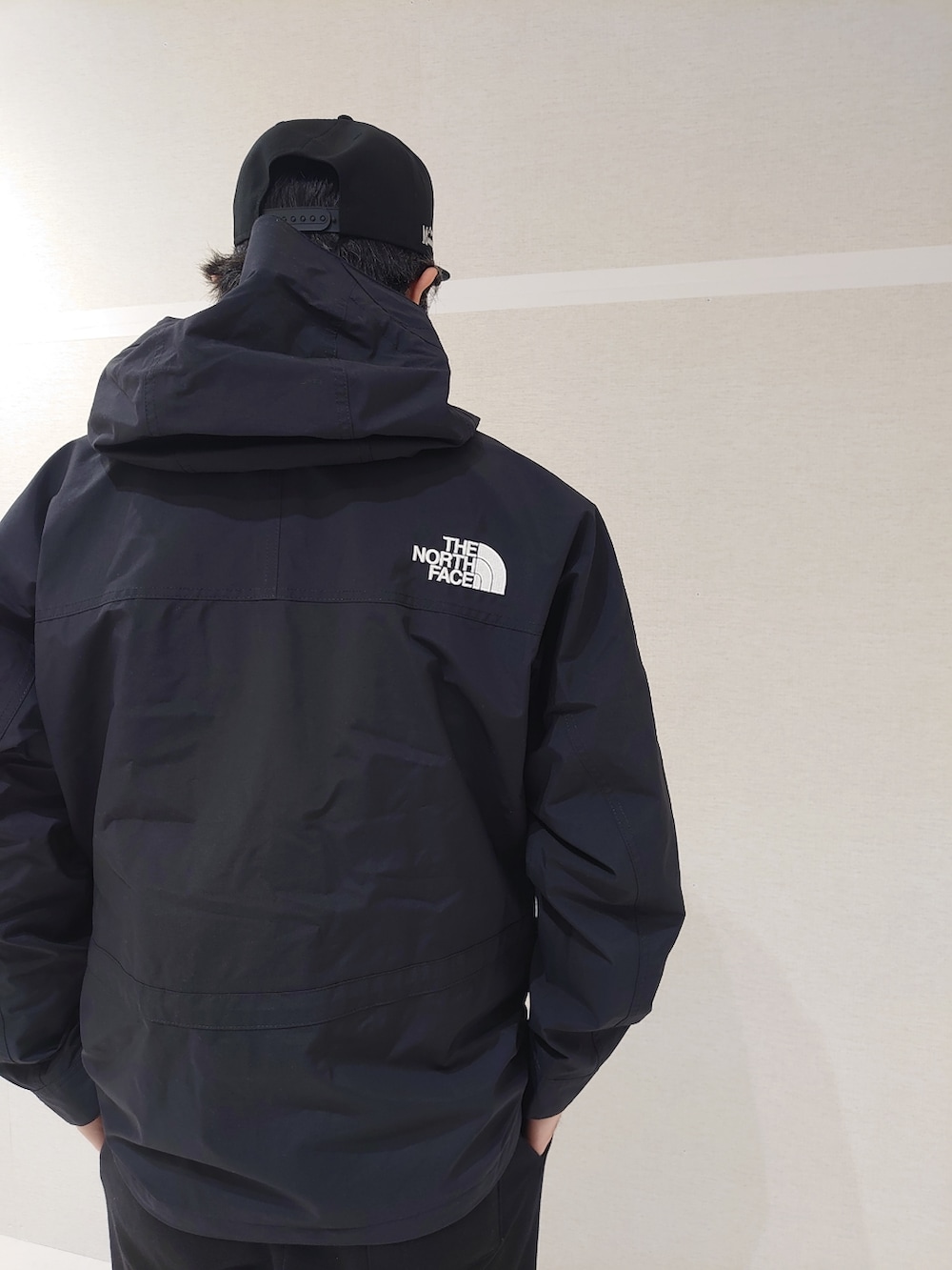 ブラック系のスウェットパンツ、ブラック系のサンダル、グリーン系のダウンジャケット/コートを着用したメンズの冬コーディネートの3枚目の写真