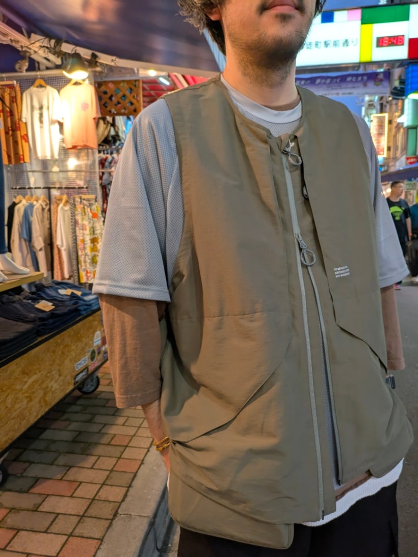 グレー系のベスト、ブラック系のカーゴパンツ、グレー系のTシャツ/カットソーを着用したメンズの春コーディネートの2枚目の写真