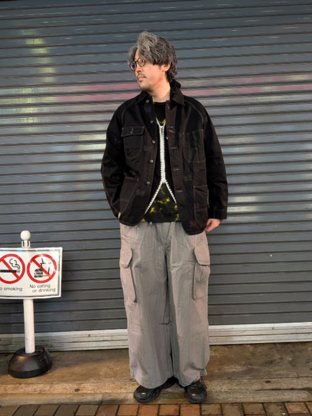 ブラック系のパーカー、グレー系のカーゴパンツを着用したメンズの春コーディネートの2枚目の写真