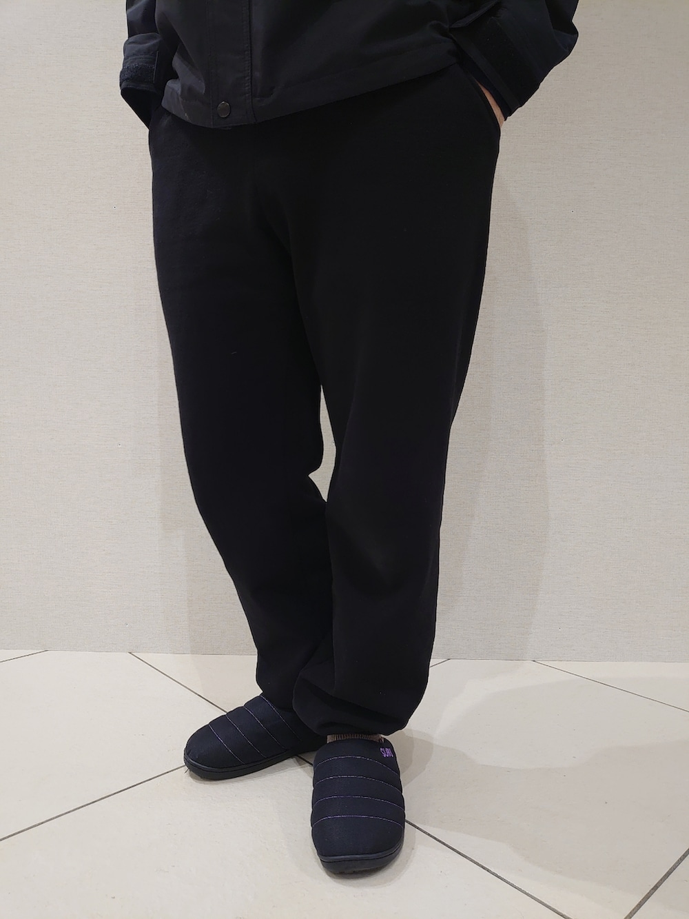 ブラック系のスウェットパンツ、ブラック系のサンダル、グリーン系のダウンジャケット/コートを着用したメンズの冬コーディネートの4枚目の写真