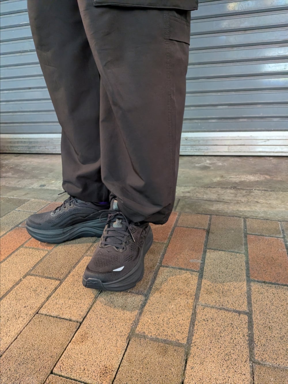 ブラック系のシャツ/ブラウス、ブラック系のカーゴパンツ、ブラック系のスニーカーを着用したメンズの冬コーディネートの4枚目の写真