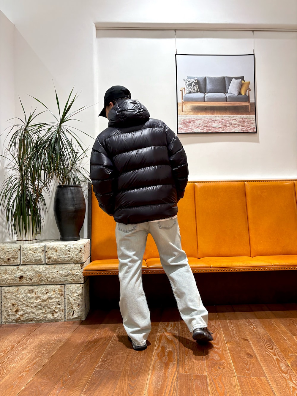 ブラック系のスニーカー、ブルー系のデニムパンツ、ブラック系のダウンジャケット/コートを着用したメンズの冬コーディネートの3枚目の写真