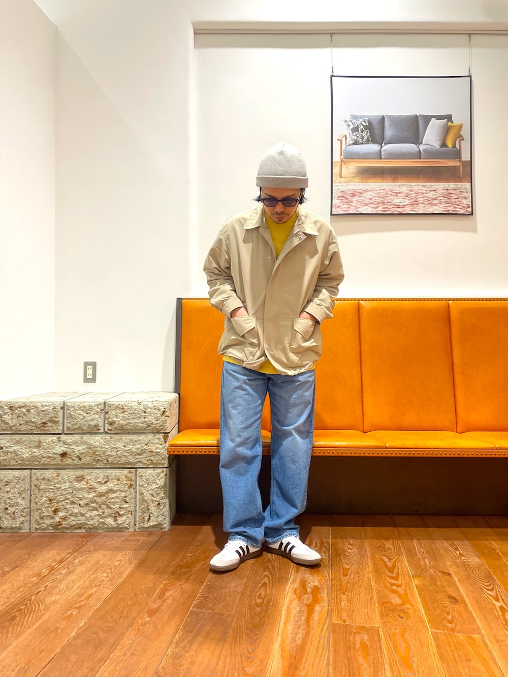 ホワイト系のスニーカー、ブルー系のデニムパンツ、ベージュ系のナイロンジャケットを着用したメンズの春コーディネートの2枚目の写真