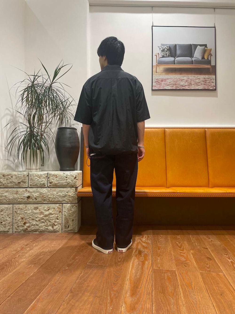 ブルー系のデニムパンツ、ブラック系のスニーカー、ホワイト系のTシャツ/カットソーを着用したメンズの夏コーディネートの4枚目の写真