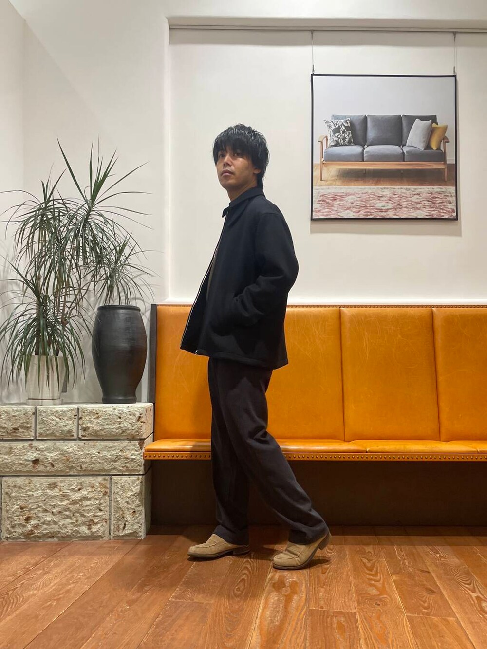 ブラック系のビジネスバッグ、ブラウン系のニット/セーター、グレー系のその他パンツを着用したメンズの秋コーディネートの2枚目の写真