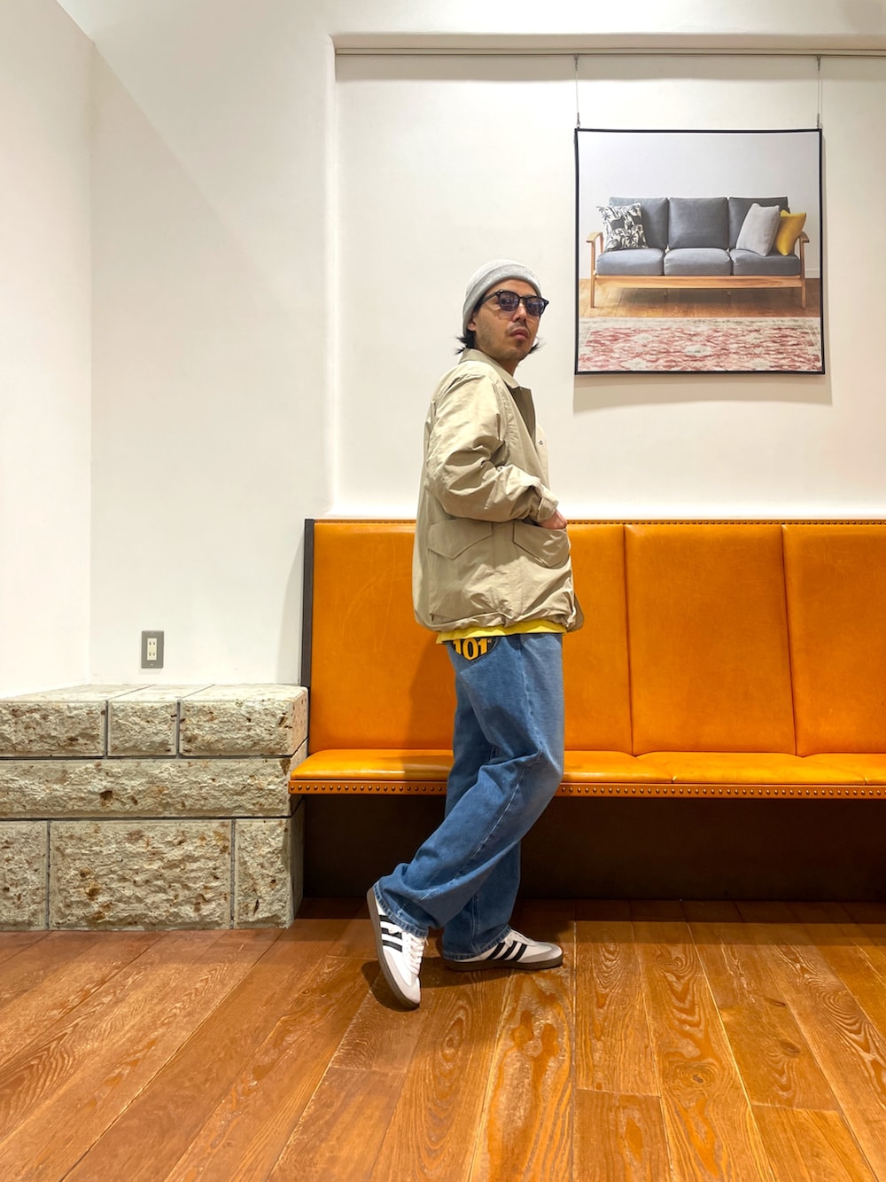 ホワイト系のスニーカー、ブルー系のデニムパンツ、ベージュ系のナイロンジャケットを着用したメンズの春コーディネートの3枚目の写真