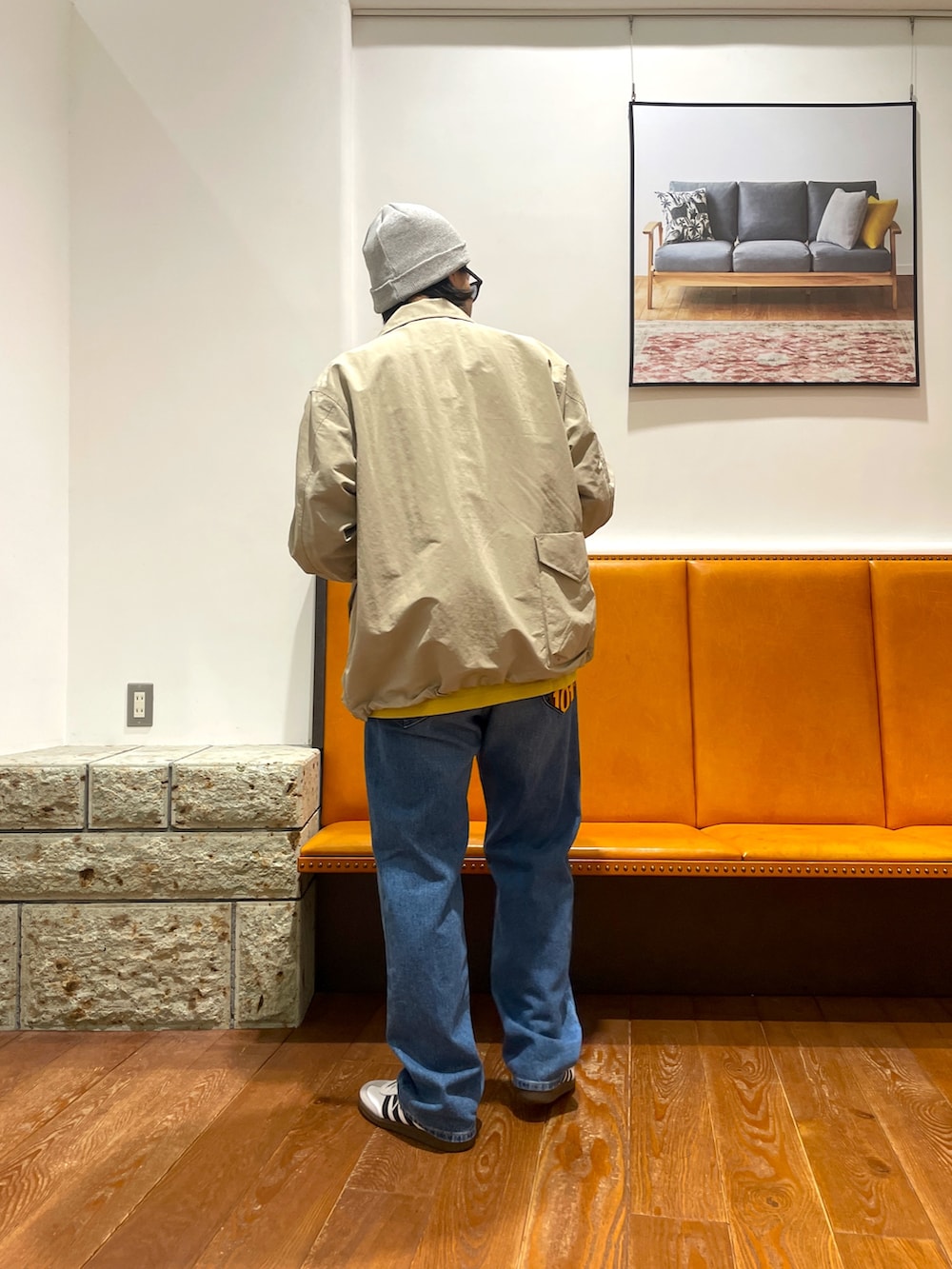 ホワイト系のスニーカー、ブルー系のデニムパンツ、ベージュ系のナイロンジャケットを着用したメンズの春コーディネートの4枚目の写真