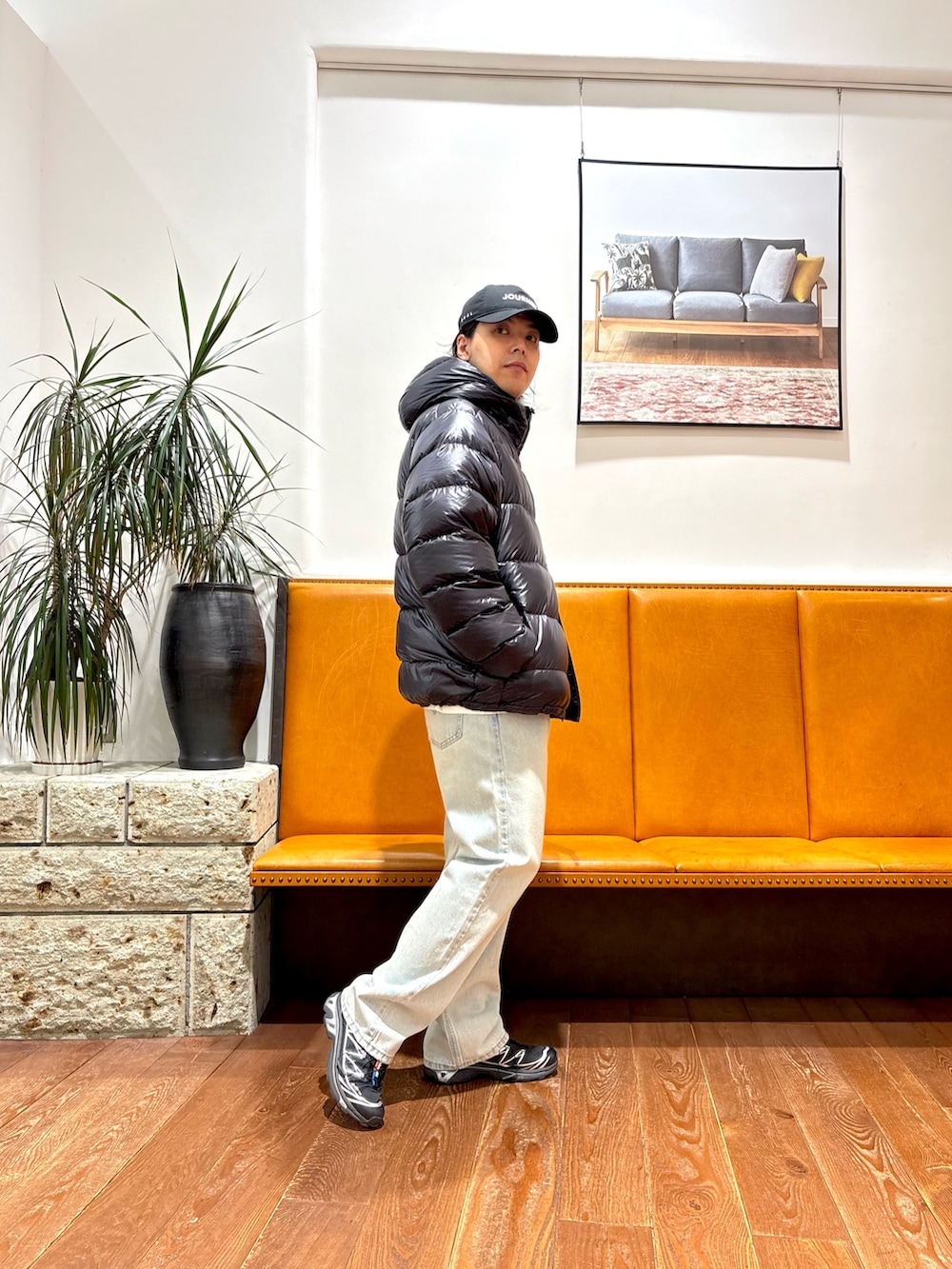 ブラック系のスニーカー、ブルー系のデニムパンツ、ブラック系のダウンジャケット/コートを着用したメンズの冬コーディネートの2枚目の写真