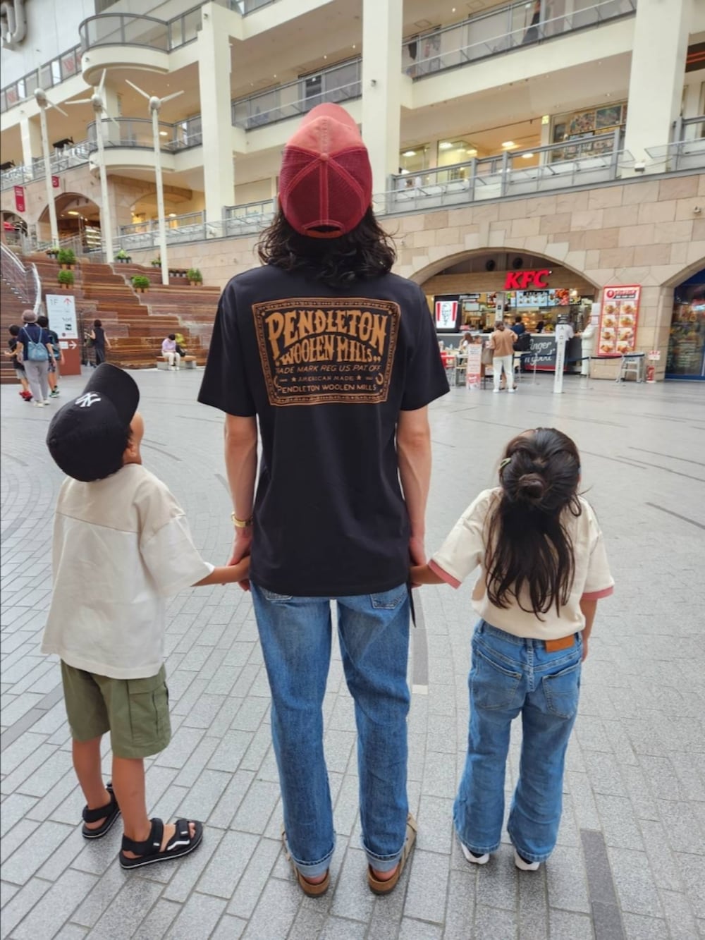 グリーン系のカーゴパンツ、ブラック系のサンダル、ブルー系のデニムパンツを着用したメンズの夏コーディネートの2枚目の写真