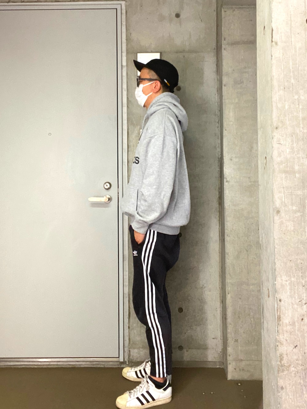 ブラック系のその他パンツ、ホワイト系のスニーカー、グレー系のパーカーを着用したメンズの秋コーディネートの2枚目の写真