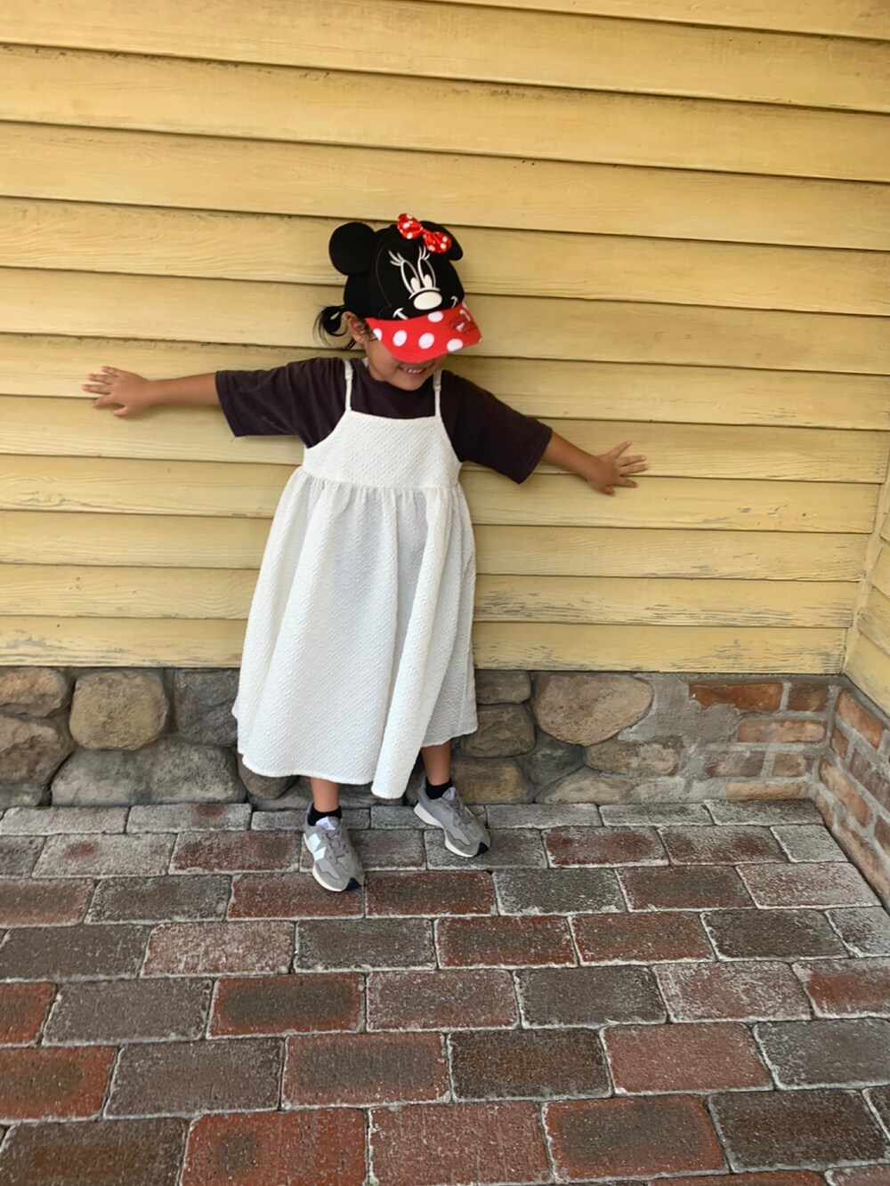 ブラック系のTシャツ/カットソー、ホワイト系のワンピース、グレー系のスニーカーを着用したキッズの夏コーディネートの2枚目の写真