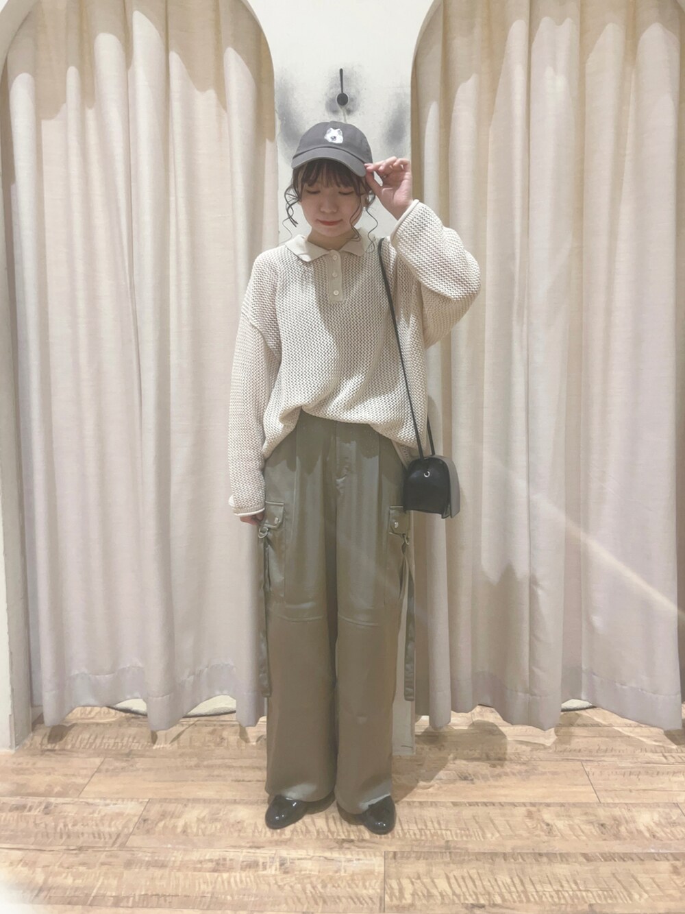 グリーン系のその他パンツ、ホワイト系のニット/セーター、ブルー系のハンドバッグを着用したレディースの春コーディネートの2枚目の写真