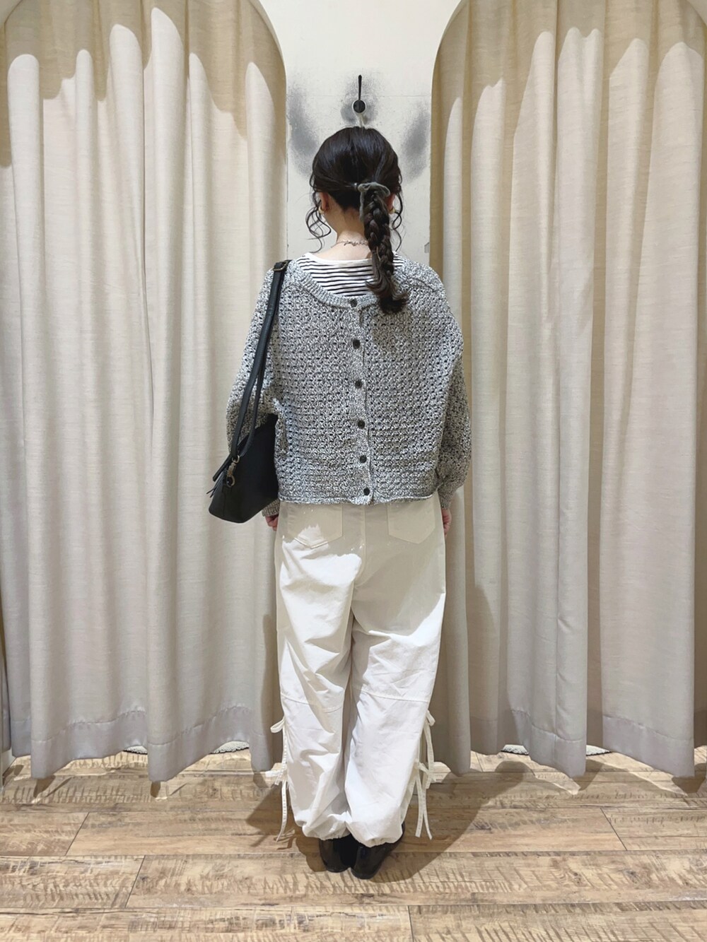 ホワイト系のその他パンツ、ブラック系のカーディガン/ボレロ、ブラック系のハンドバッグを着用したレディースの冬コーディネートの2枚目の写真