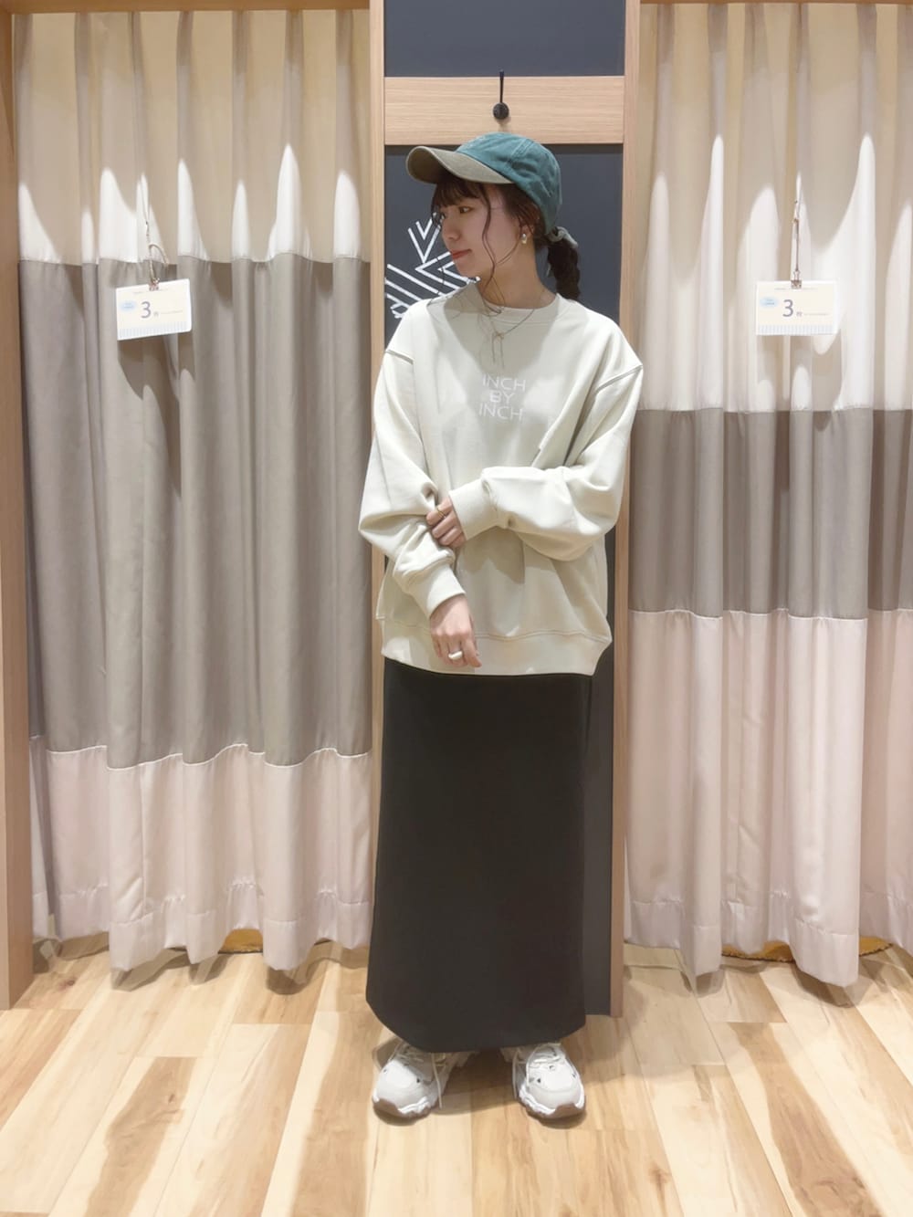 ベージュ系のTシャツ/カットソー、ブラック系のスカートを着用したレディースの秋コーディネートの2枚目の写真