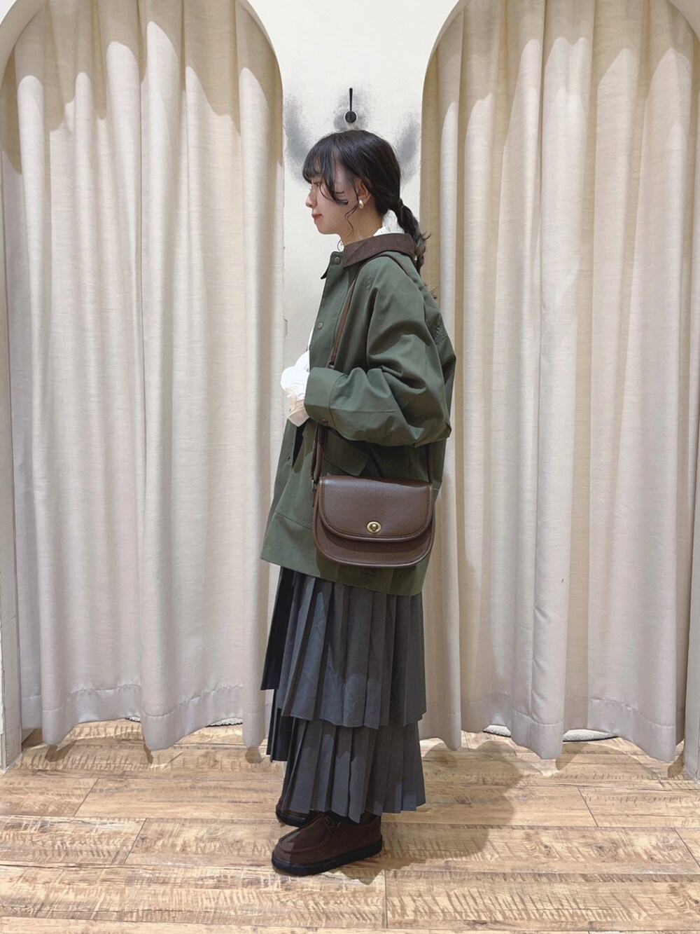 ブラウン系のその他シューズ、ブラウン系のハンドバッグ、グリーン系のブルゾンを着用したレディースの秋コーディネートの3枚目の写真