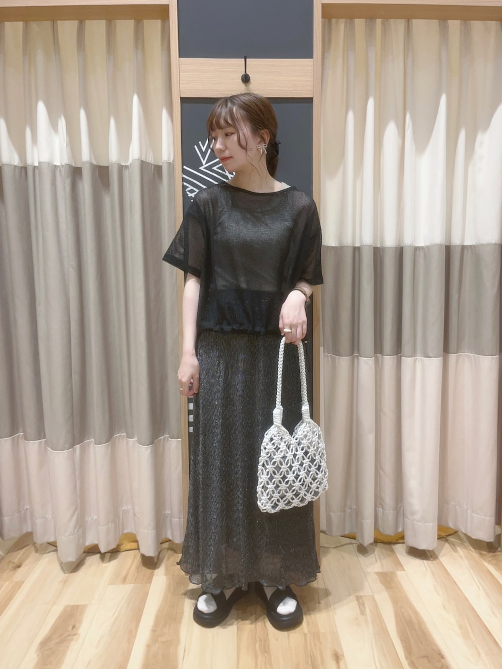 ホワイト系のハンドバッグ、ブラック系のTシャツ/カットソー、ブラック系のスカートを着用したレディースの夏コーディネートの2枚目の写真