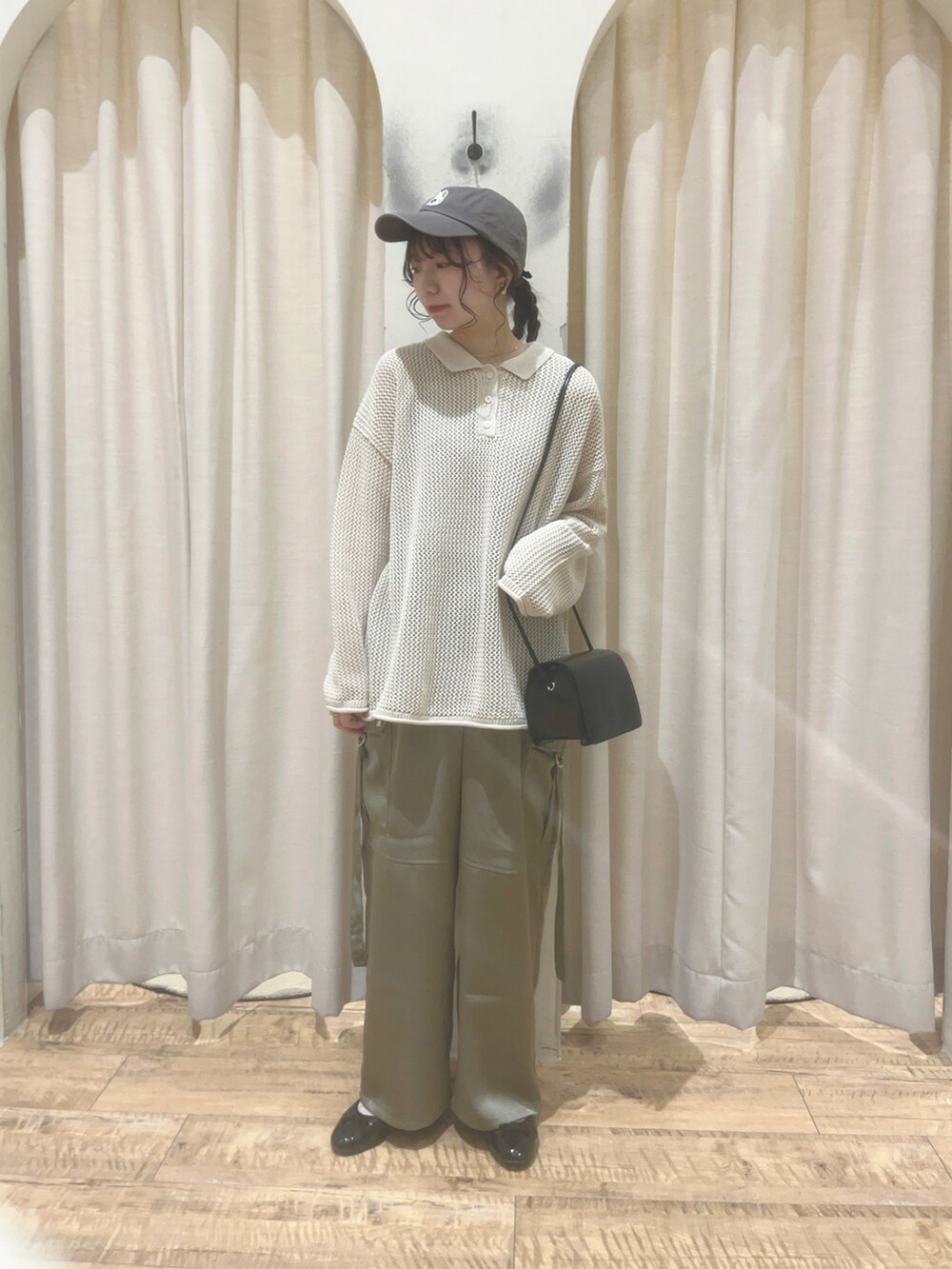 グリーン系のその他パンツ、ホワイト系のニット/セーター、ブルー系のハンドバッグを着用したレディースの春コーディネートの3枚目の写真