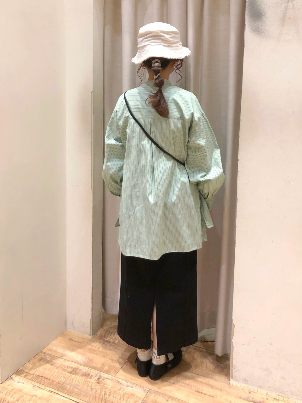 グリーン系のシャツ/ブラウス、ブラック系のスカート、ブラック系のその他シューズを着用したレディースの春コーディネートの2枚目の写真