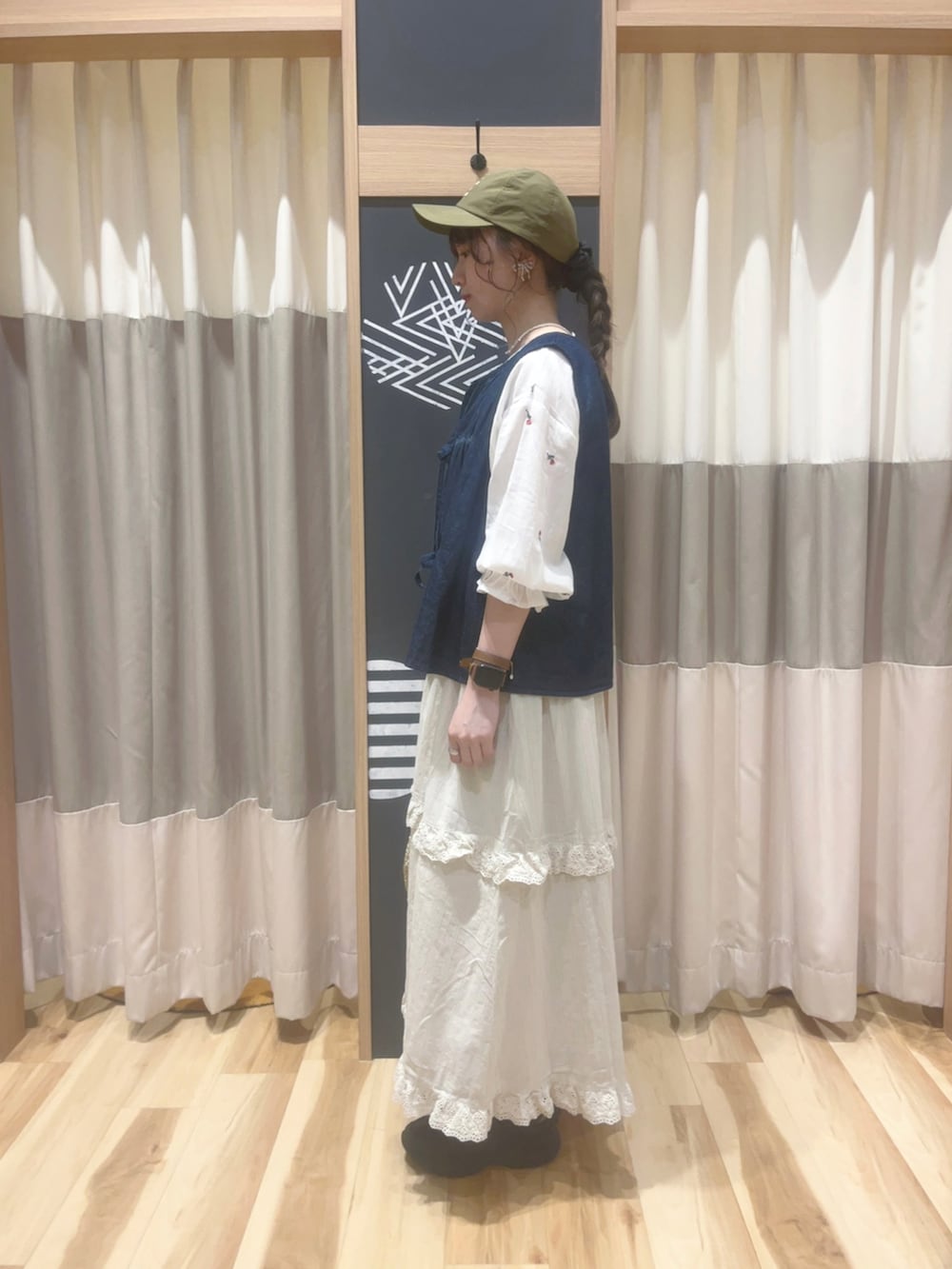 ブラック系のドレスシューズ、ゴールド系のハンドバッグ、ベージュ系のスカートを着用したレディースの春コーディネートの2枚目の写真