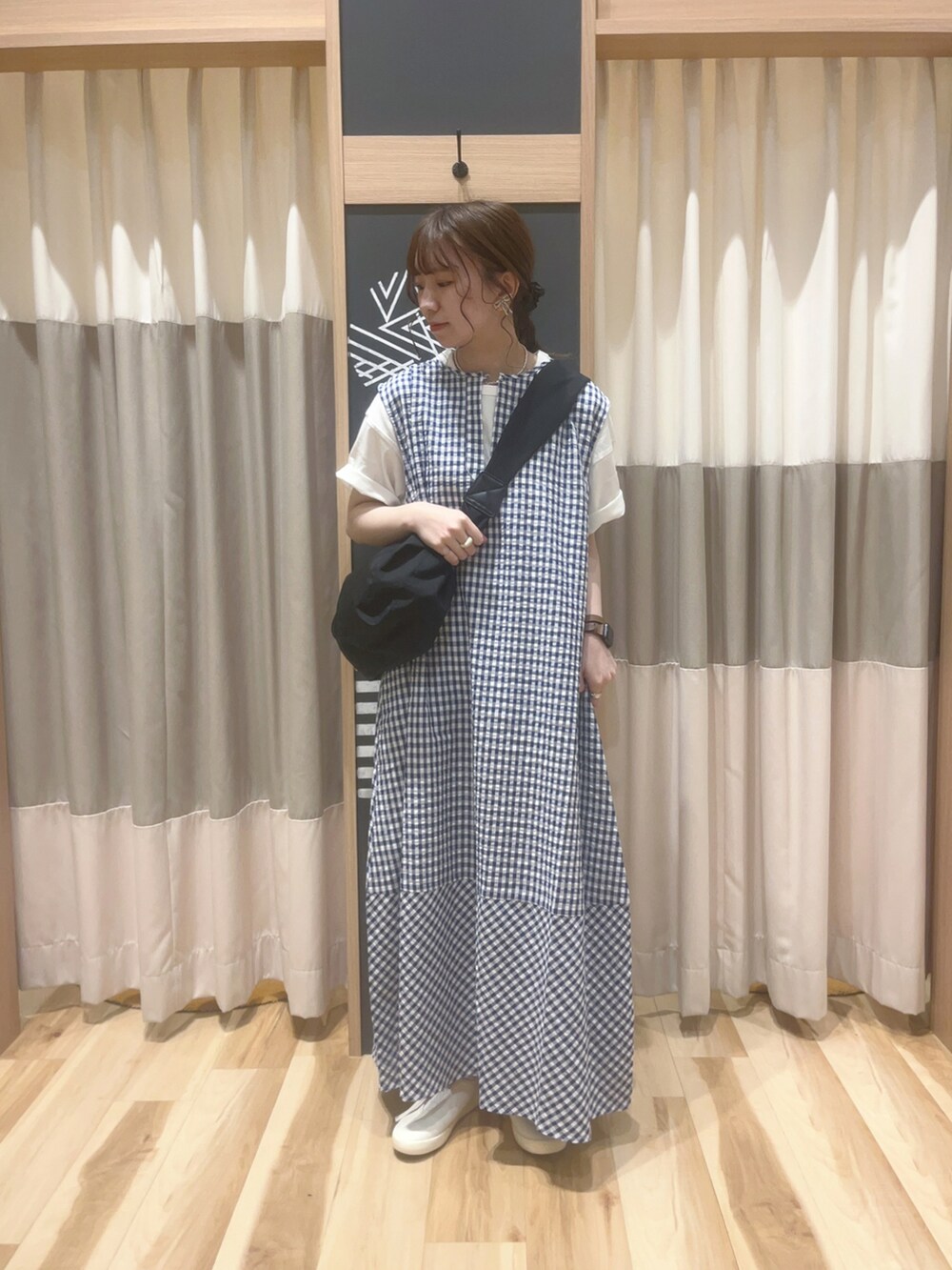 ブルー系のワンピース/ドレス、ブラック系のハンドバッグ、ホワイト系のスニーカーを着用したレディースの春コーディネートの2枚目の写真