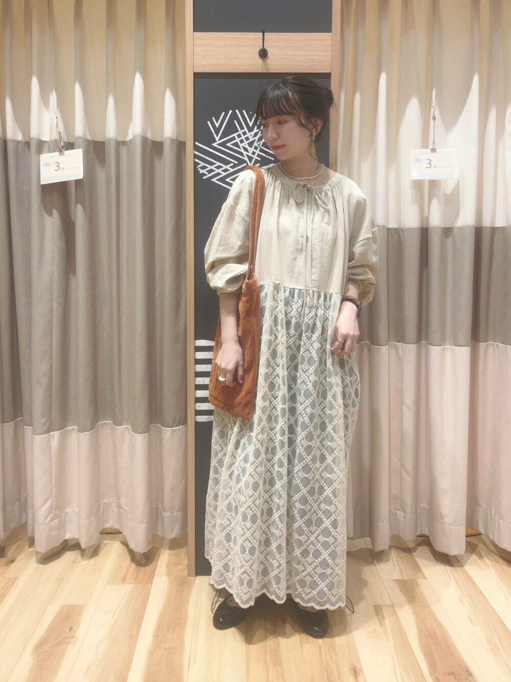 オレンジ系のハンドバッグ、グリーン系のその他パンツ、ホワイト系のワンピースを着用したレディースの秋コーディネートの2枚目の写真