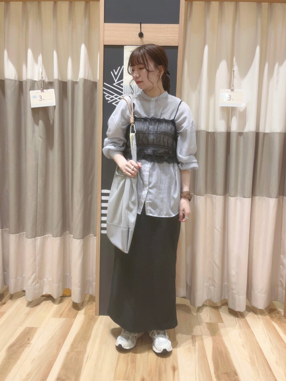 ブラック系のスカート、ブルー系のシャツ/ブラウス、ブラック系のTシャツ/カットソーを着用したレディースの春コーディネートの2枚目の写真