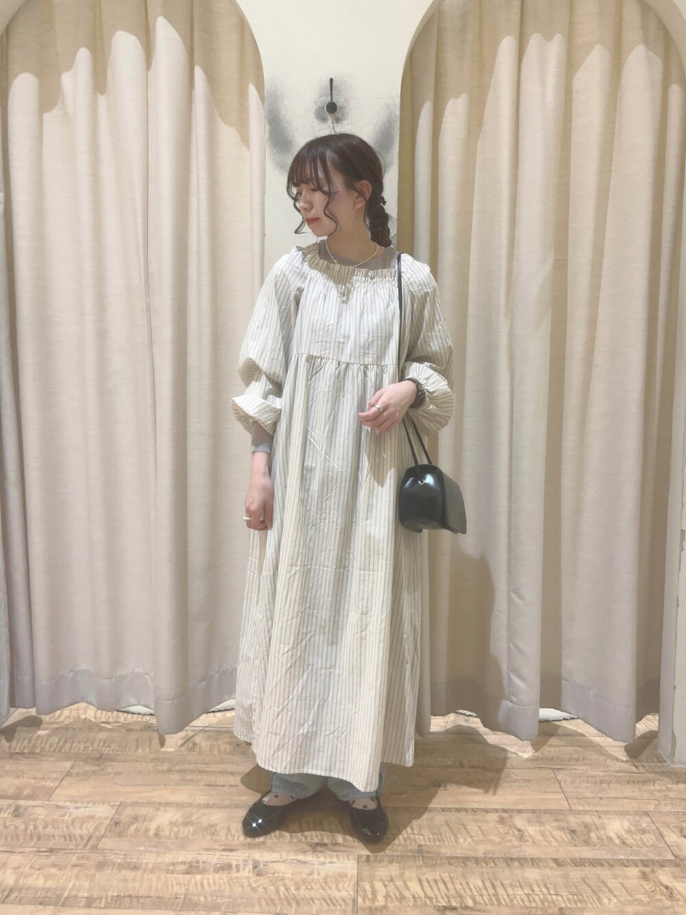 ホワイト系のワンピース、グレー系のTシャツ/カットソー、ブルー系のデニムパンツを着用したレディースの春コーディネートの3枚目の写真