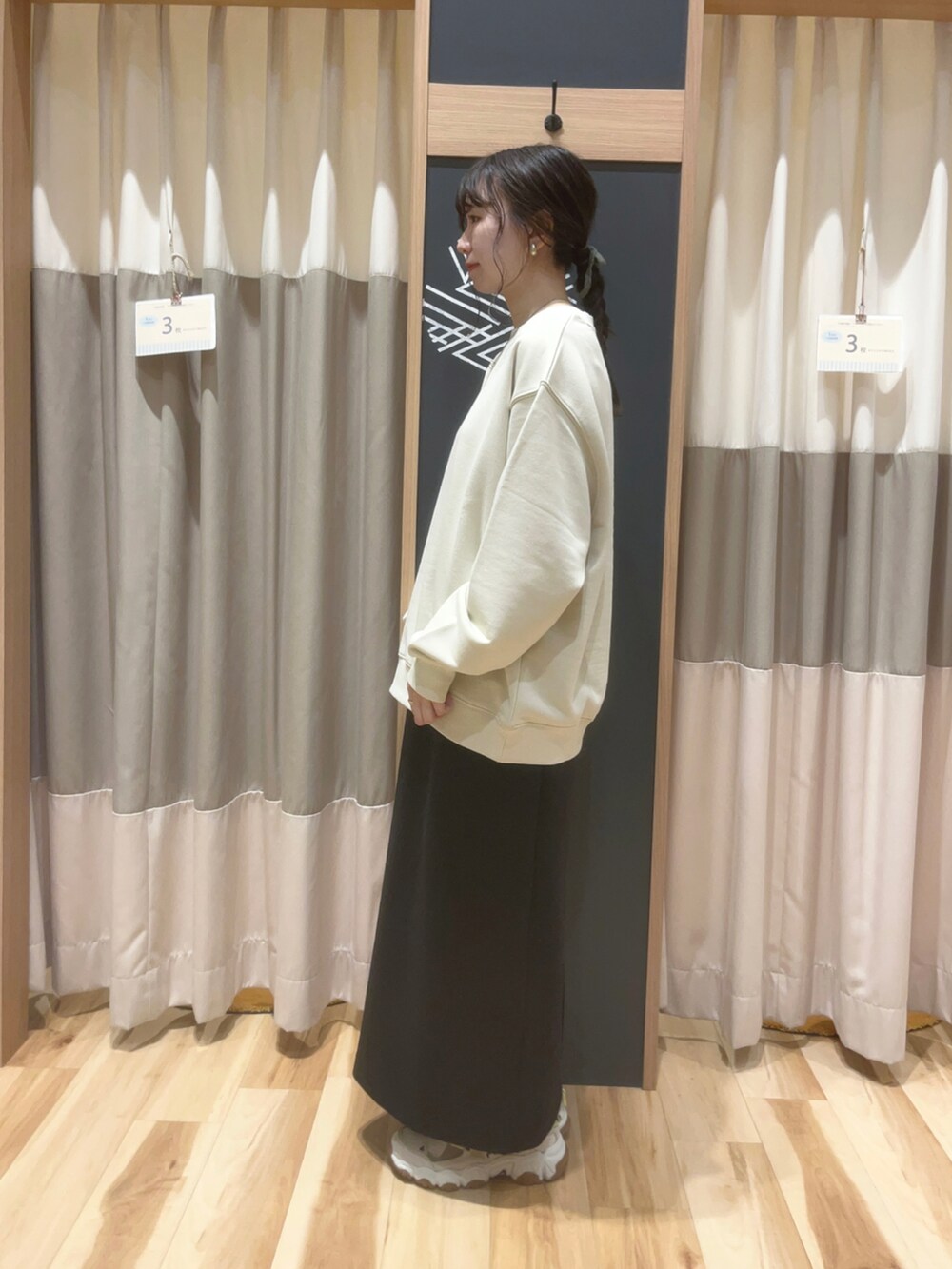 ベージュ系のTシャツ/カットソー、ブラック系のスカートを着用したレディースの秋コーディネートの3枚目の写真