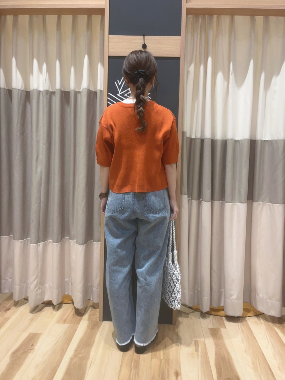 オレンジ系のカーディガン/ボレロ、ホワイト系のTシャツ/カットソー、ホワイト系のハンドバッグを着用したレディースの春コーディネートの3枚目の写真