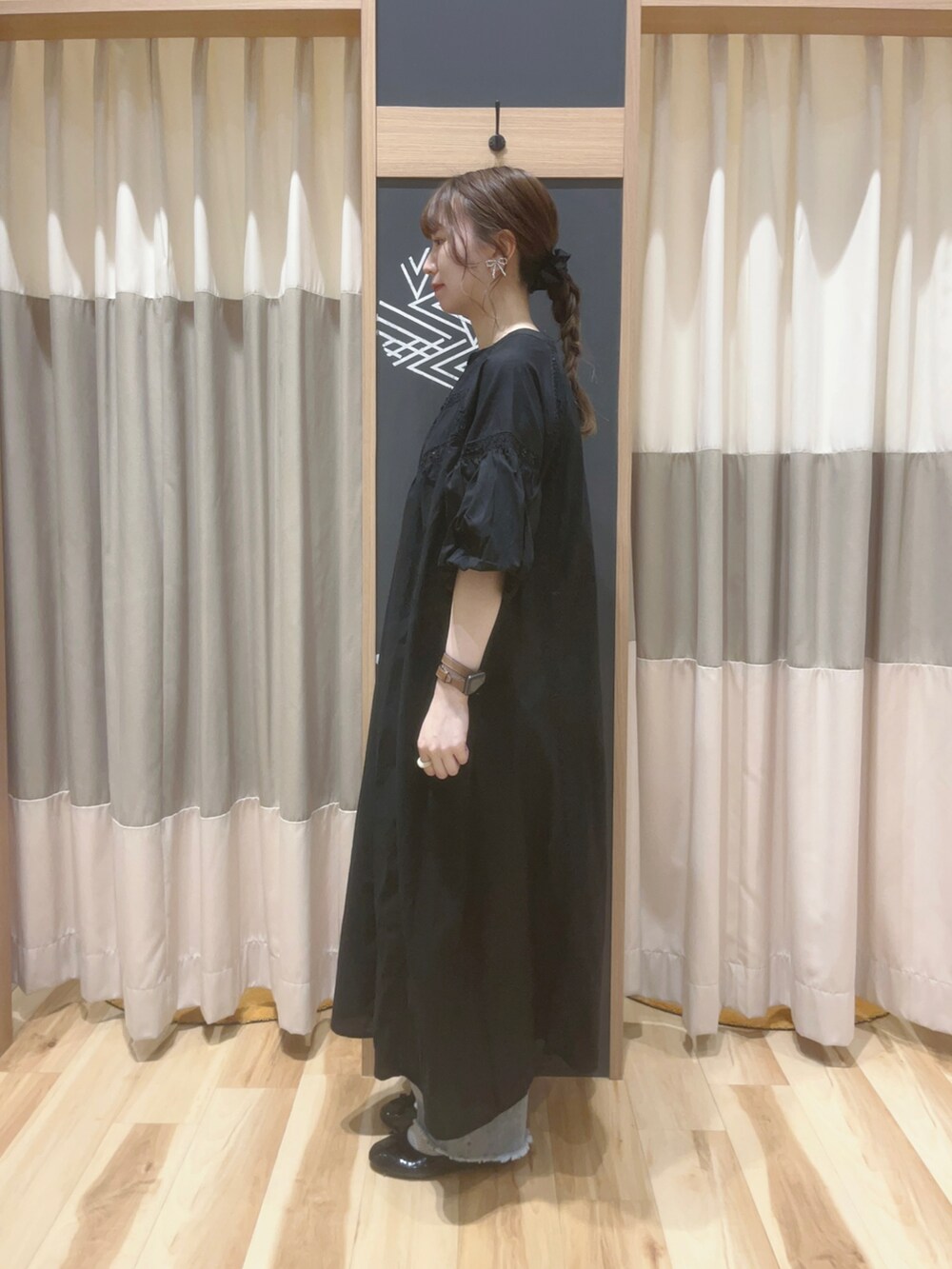 シルバー系のハンドバッグ、ブラック系のパンプス、ブラック系のワンピースを着用したレディースの夏コーディネートの2枚目の写真