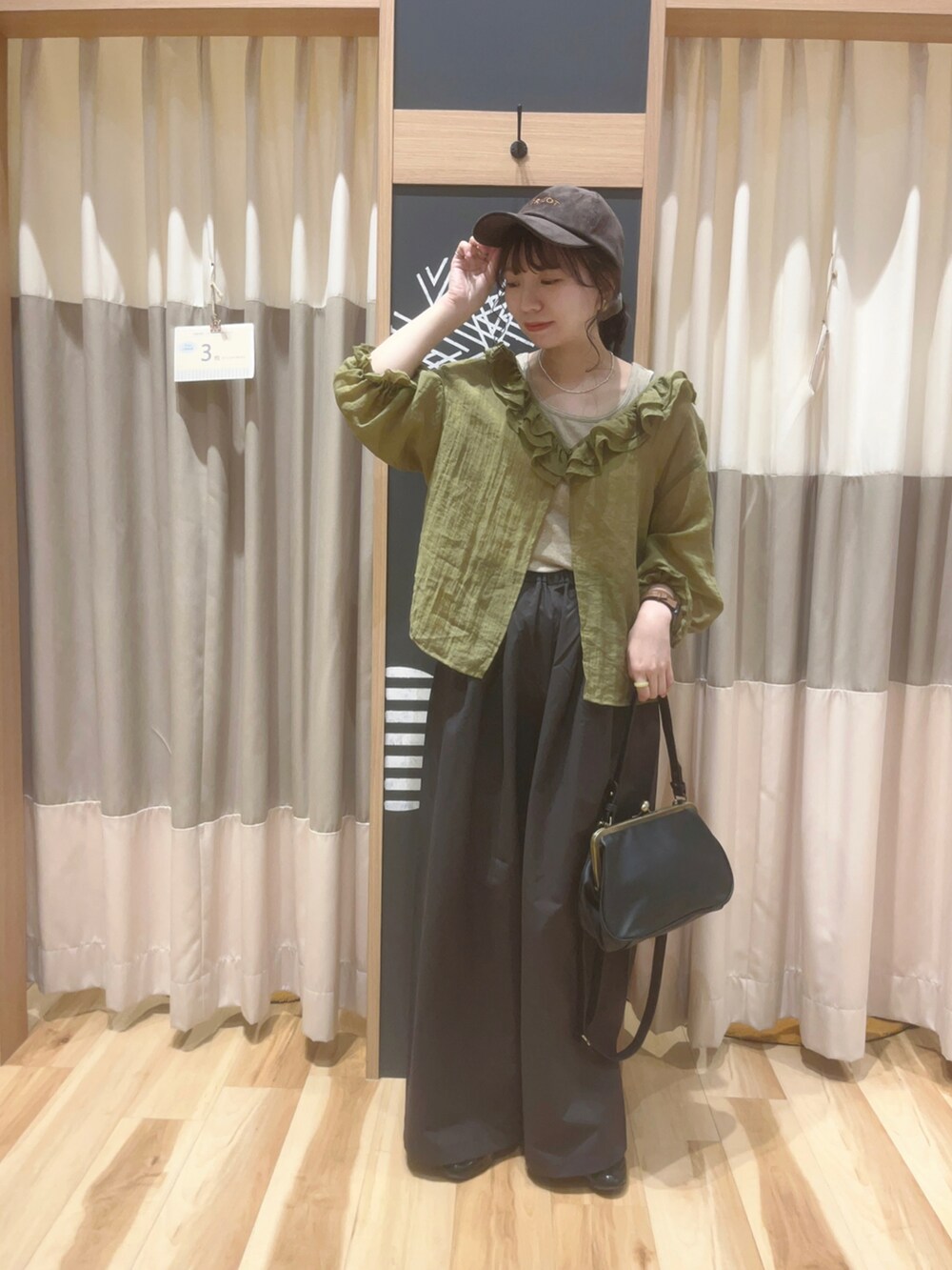 ベージュ系のTシャツ/カットソー、ブラック系のハンドバッグ、グリーン系のシャツ/ブラウスを着用したレディースの夏コーディネートの2枚目の写真