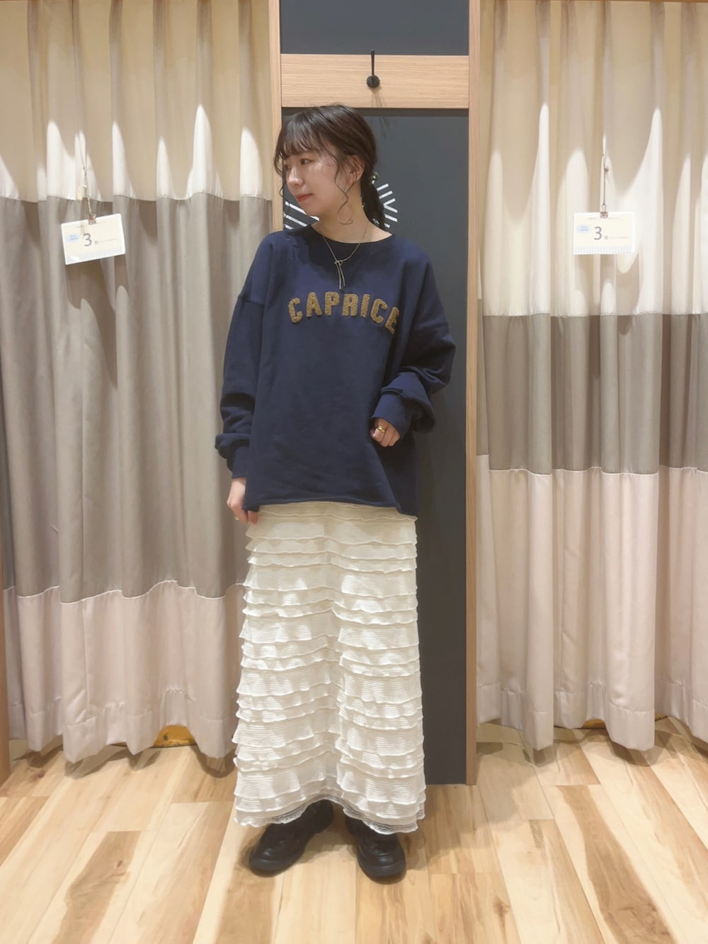 ブラック系のローファー、ブルー系のTシャツ/カットソー、ホワイト系のスカートを着用したレディースの秋コーディネートの2枚目の写真