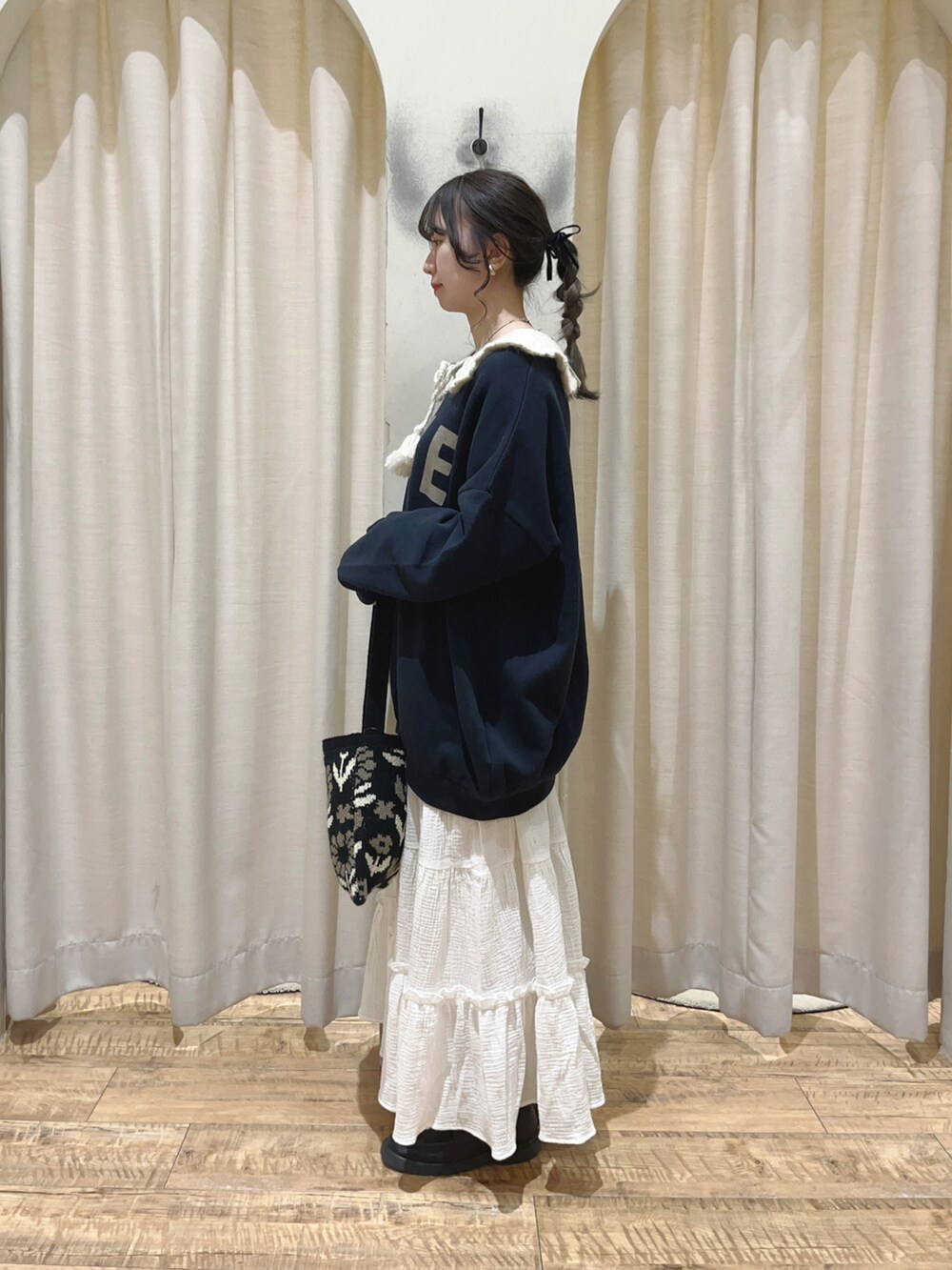 ブルー系のTシャツ/カットソー、ホワイト系のスカート、ブラック系のハンドバッグを着用したレディースの秋コーディネートの2枚目の写真