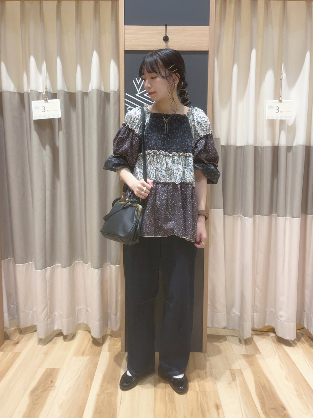 ブラック系のシャツ/ブラウス、ベージュ系のTシャツ/カットソー、ブラック系のハンドバッグを着用したレディースの秋コーディネートの3枚目の写真