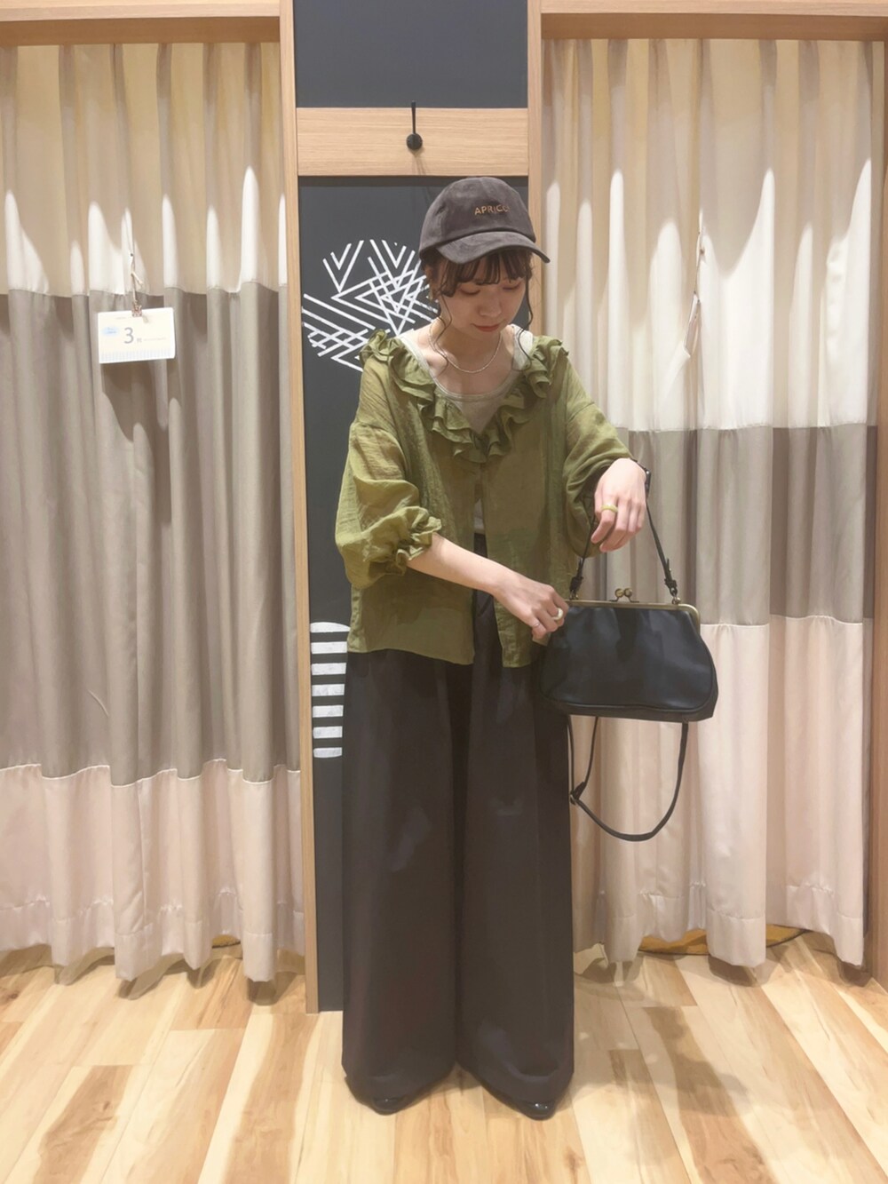 ベージュ系のTシャツ/カットソー、ブラック系のハンドバッグ、グリーン系のシャツ/ブラウスを着用したレディースの夏コーディネートの3枚目の写真