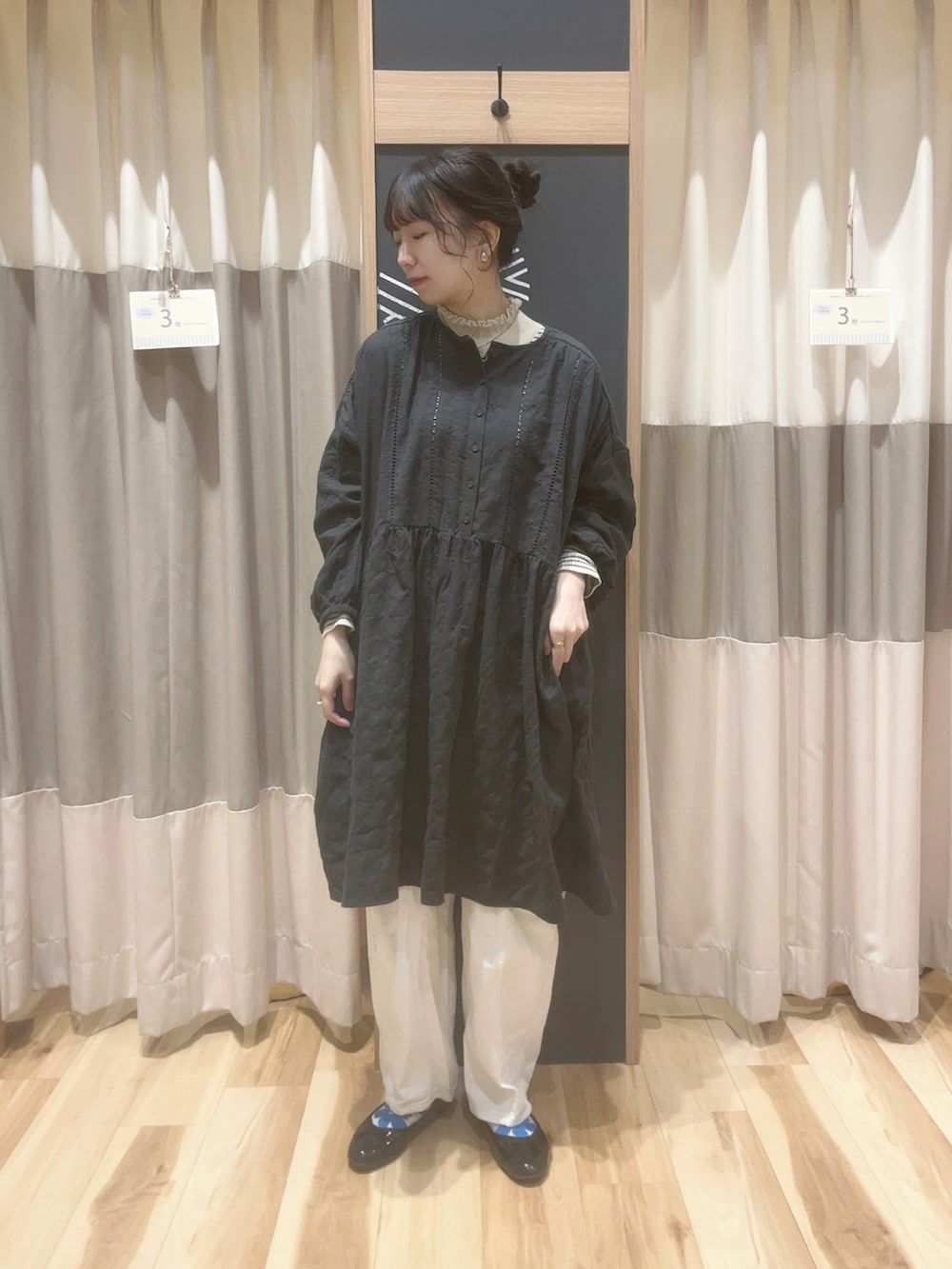 グレー系のチュニック、ホワイト系のニット/セーターを着用したレディースの冬コーディネートの2枚目の写真