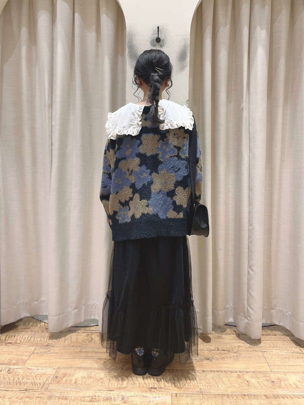 ブラック系のローファー、ブラック系のスカート、ブラック系のハンドバッグを着用したレディースの秋コーディネートの3枚目の写真