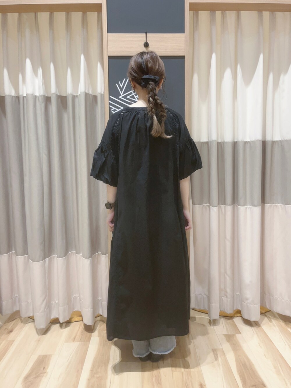 シルバー系のハンドバッグ、ブラック系のパンプス、ブラック系のワンピースを着用したレディースの夏コーディネートの3枚目の写真