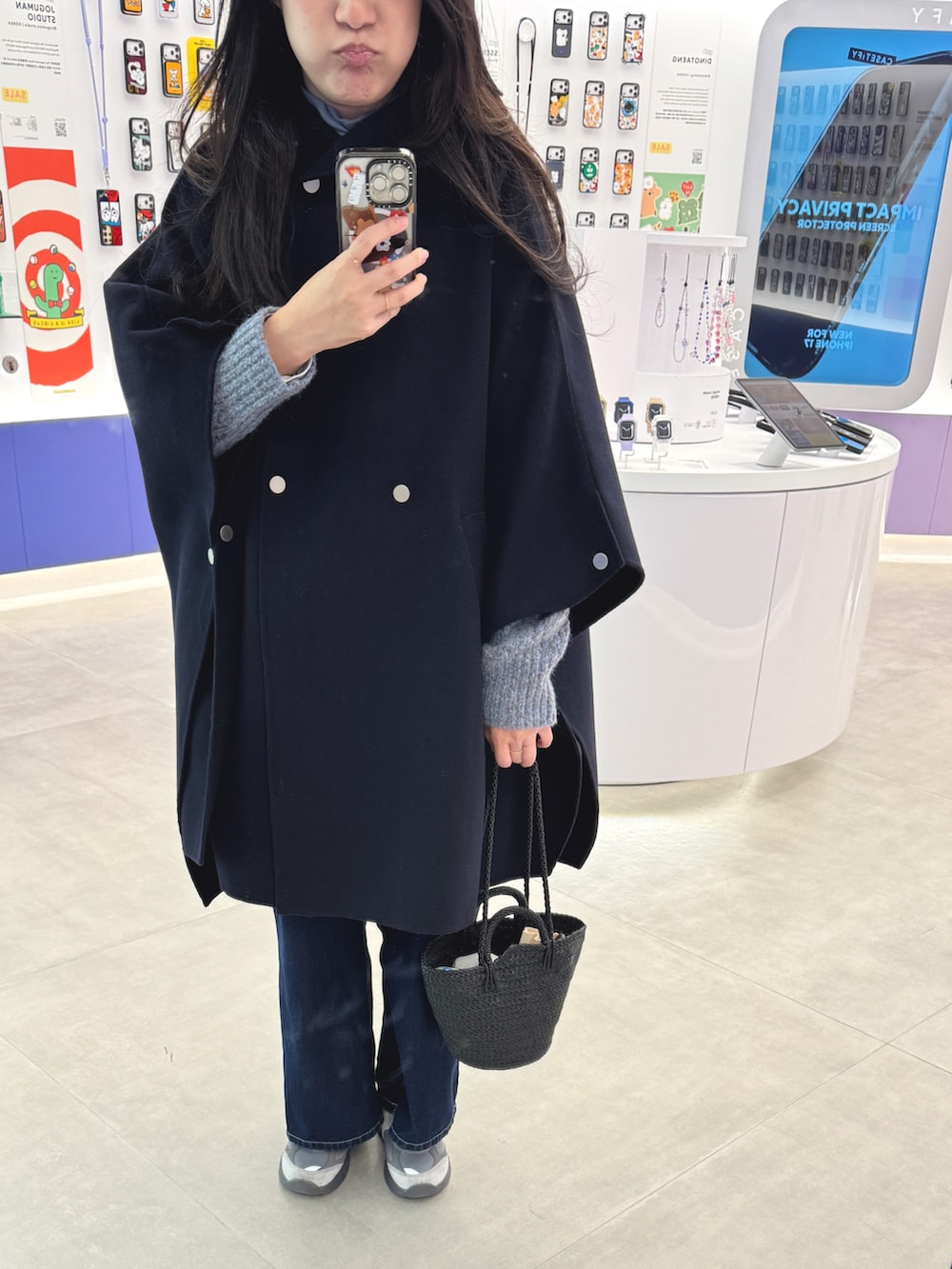 ブルー系のニット/セーター、グレー系のスニーカー、ブラック系のショルダーバッグを着用したレディースの冬コーディネートの2枚目の写真