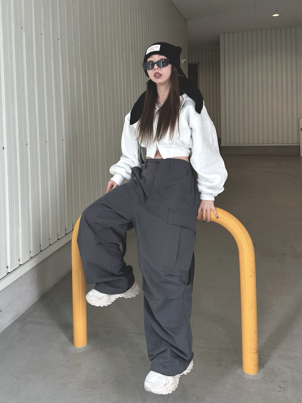 グレー系のカーゴパンツ、グレー系のバッグ、ホワイト系のパーカーを着用したレディースの冬コーディネートの3枚目の写真