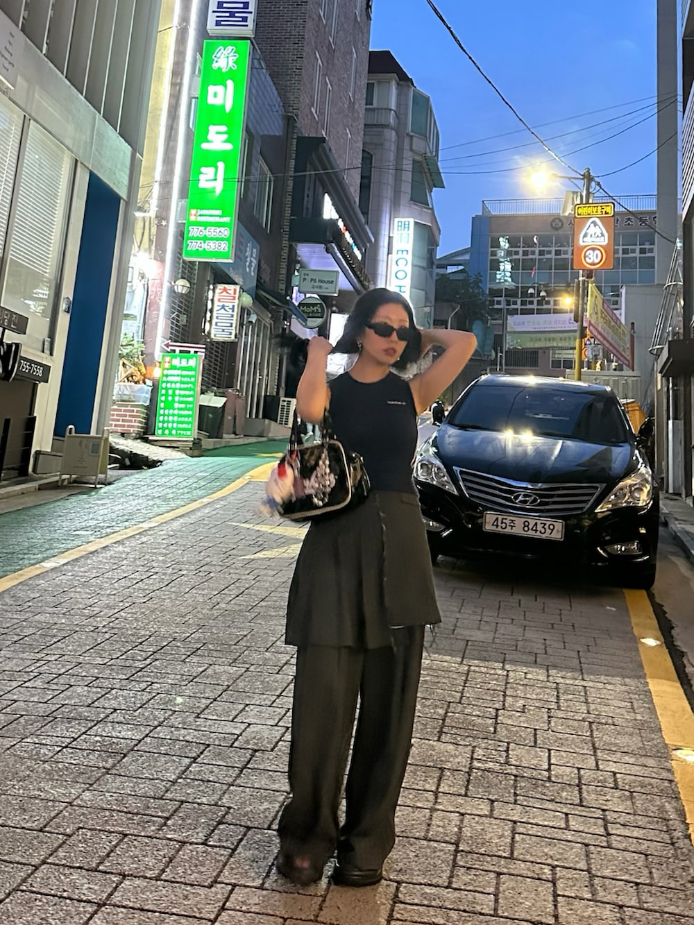 グレー系のスカート、ブルー系のタンクトップ、グレー系のスラックスを着用したレディースの秋コーディネートの2枚目の写真