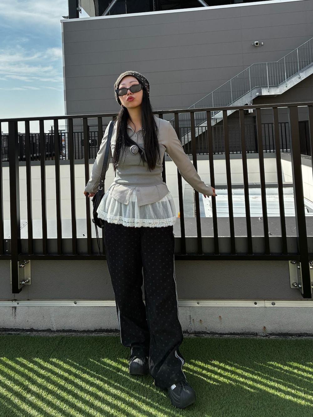 ブラック系のスニーカー、グレー系のチューブトップ、ブラック系のパンツを着用したレディースの冬コーディネートの2枚目の写真