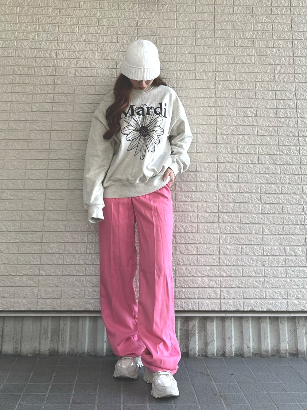 ピンク系のパンツ、グレー系のトップス、ホワイト系のスニーカーを着用したレディースの春コーディネートの2枚目の写真