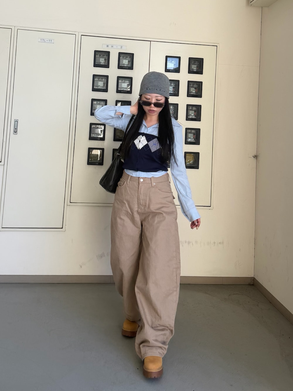 ベージュ系のブーツ、ブルー系のチューブトップ、グレー系の帽子を着用したレディースの春コーディネートの2枚目の写真