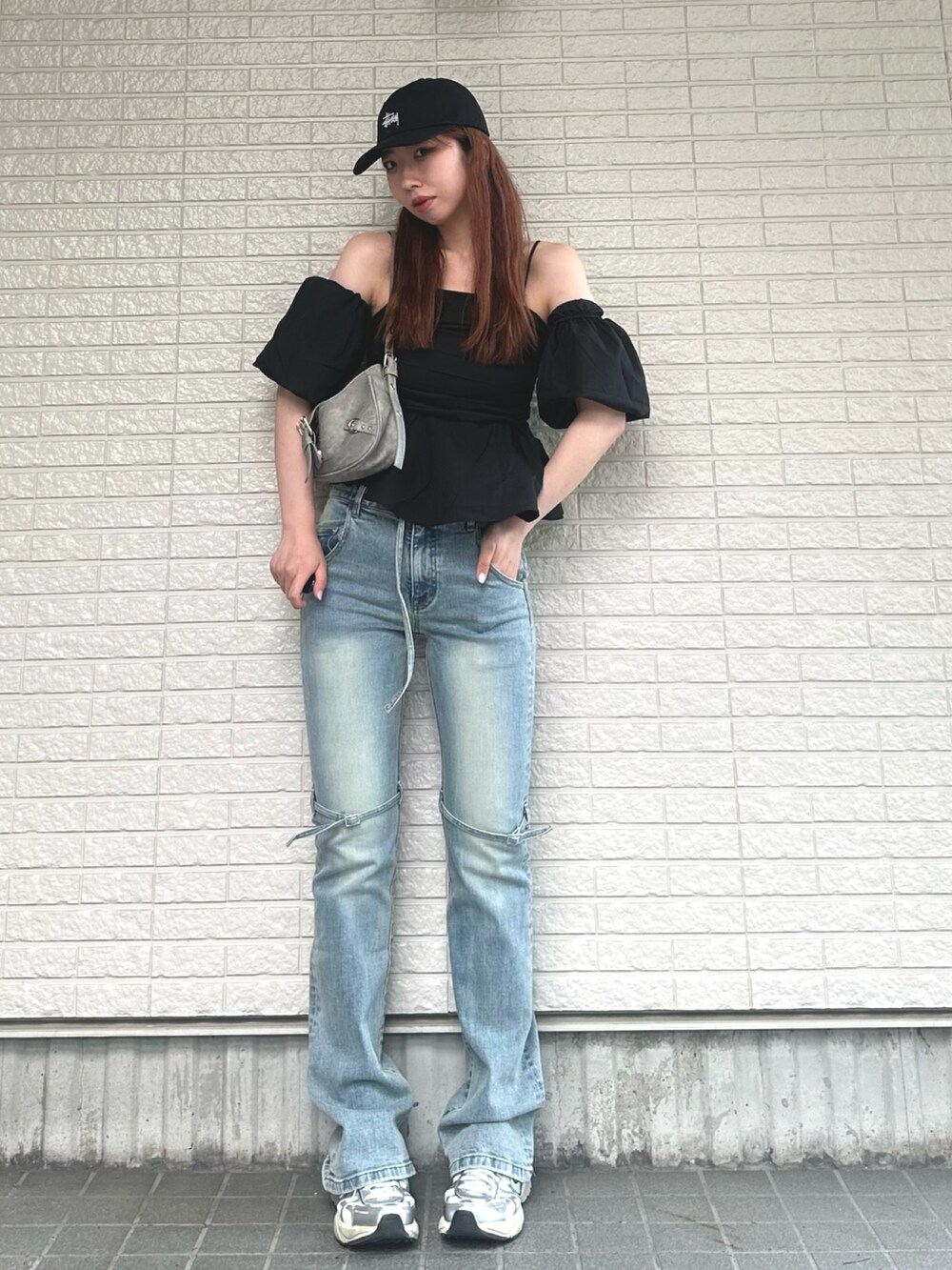 ブラック系のトップス、グレー系のバッグ、ブルー系のデニムパンツを着用したレディースの夏コーディネートの2枚目の写真