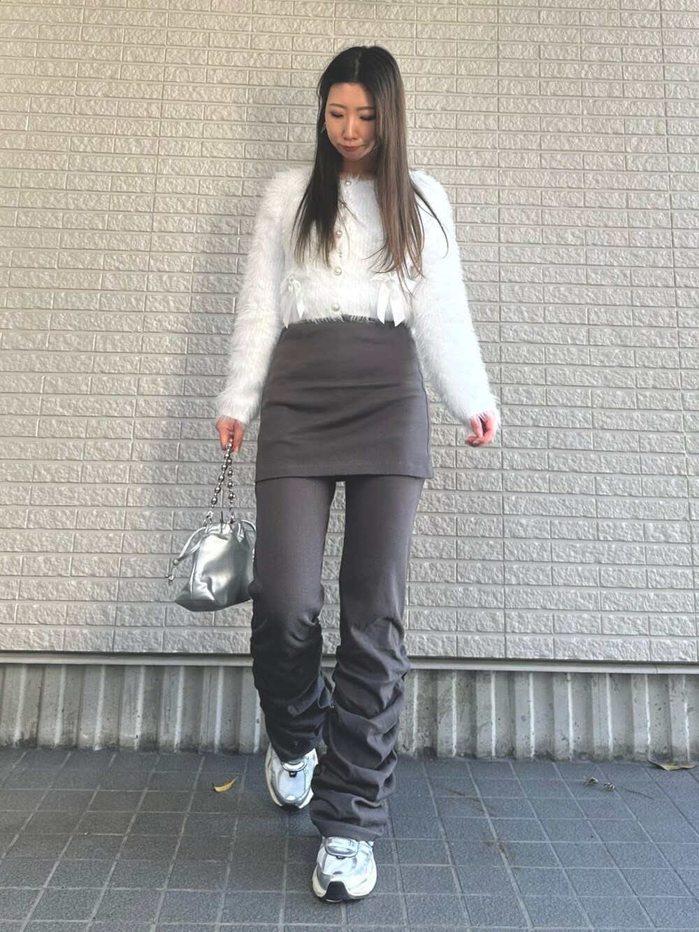 ホワイト系のニット/セーター、グレー系のその他パンツ、ホワイト系のスニーカーを着用したレディースの冬コーディネートの2枚目の写真