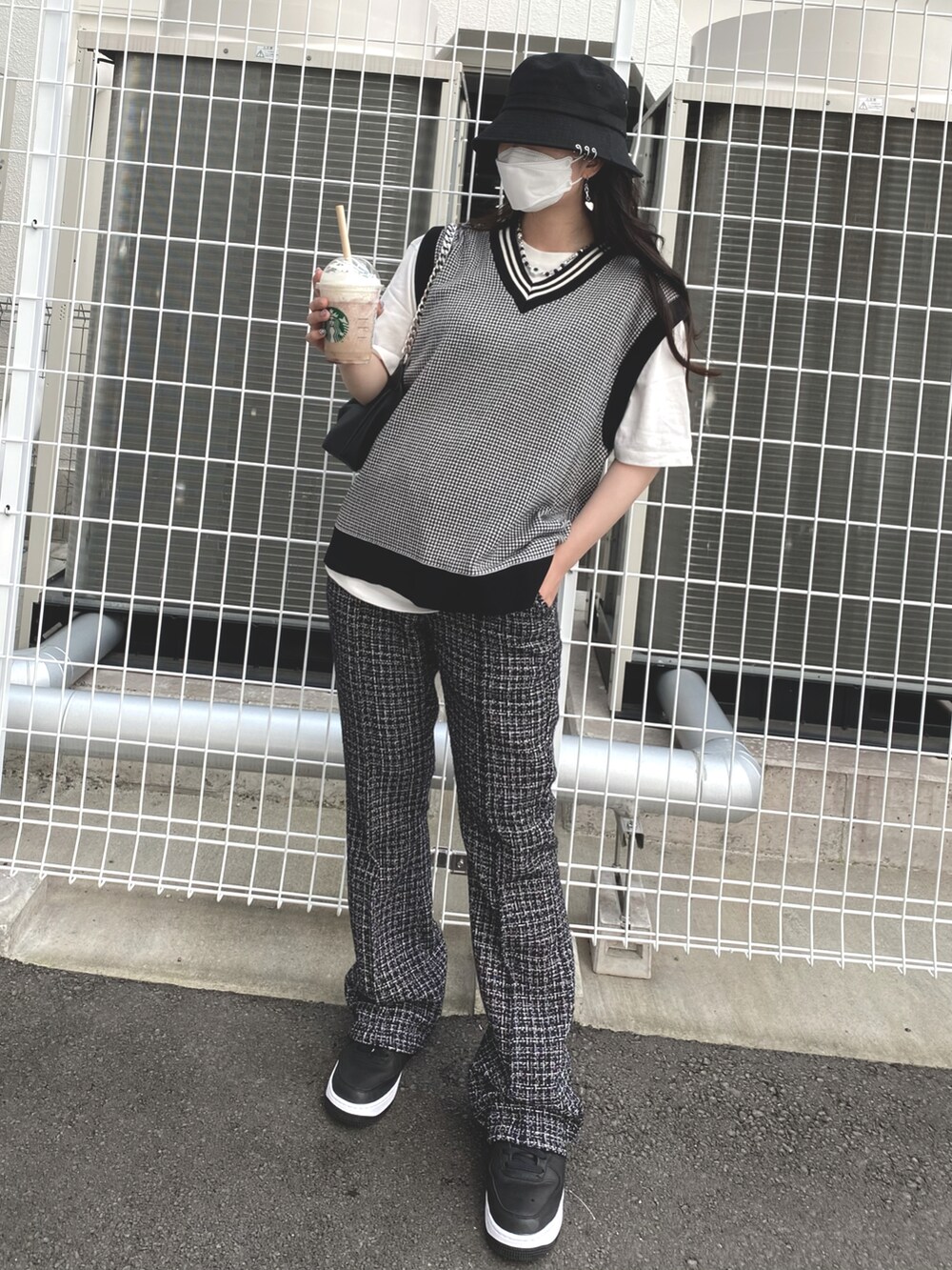 ブラック系のベスト、ブラック系のその他パンツ、ホワイト系のTシャツ/カットソーを着用したレディースの秋コーディネートの2枚目の写真