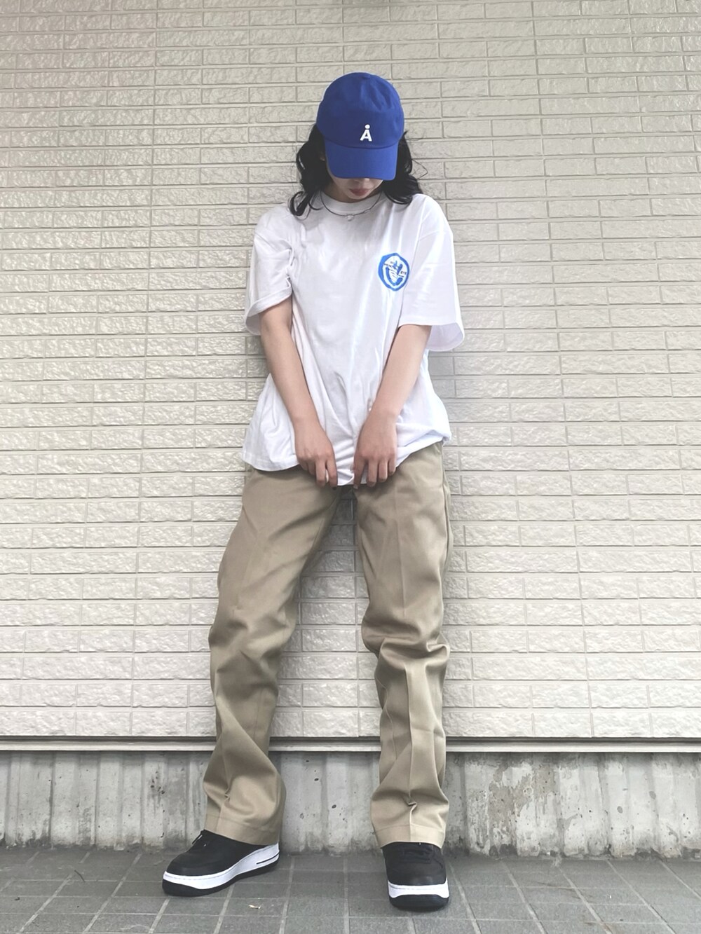 ホワイト系のTシャツ/カットソー、ベージュ系のチノパンツ、ブラック系のスニーカーを着用したレディースの夏コーディネートの2枚目の写真