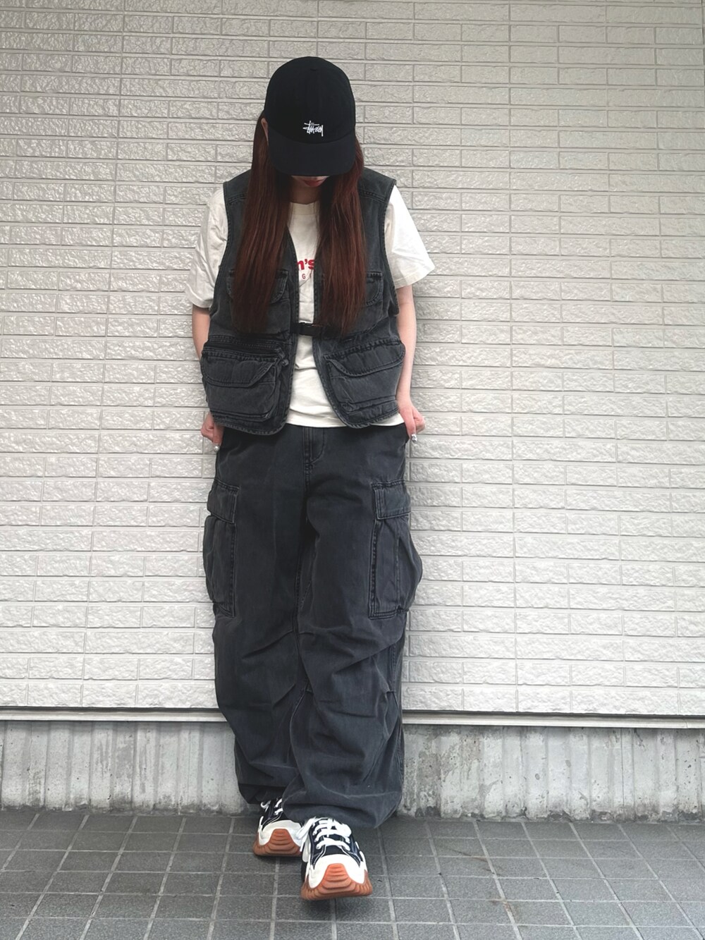 ブラック系のベスト、ブラック系のカーゴパンツ、ブラック系のスニーカーを着用したレディースの春コーディネートの2枚目の写真