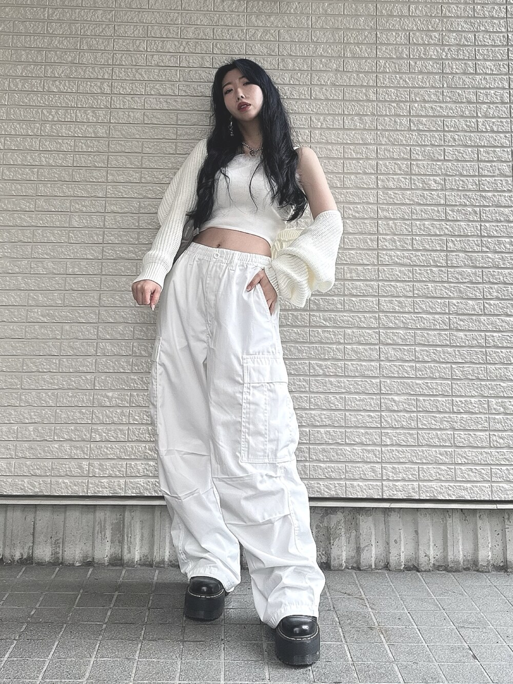 ホワイト系のカーディガン/ボレロ、ホワイト系のキャミソール、ホワイト系のカーゴパンツを着用したレディースの春コーディネートの2枚目の写真